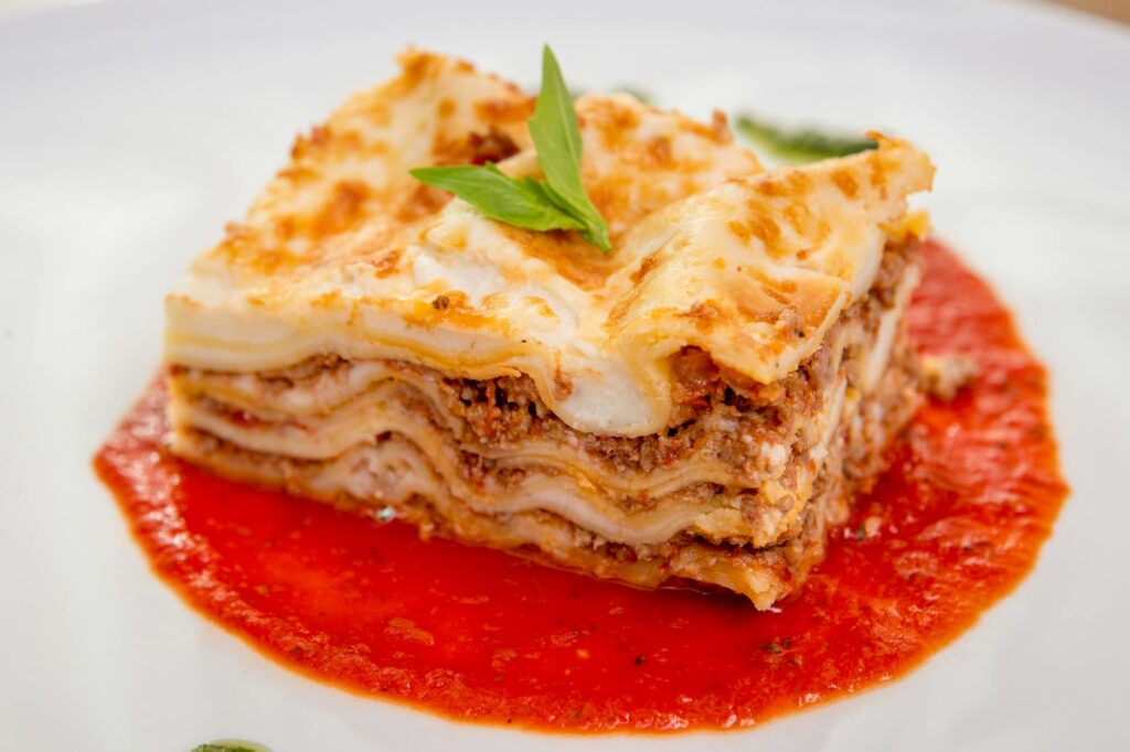 Close-up of homemade beef lasagna topped with fresh basil