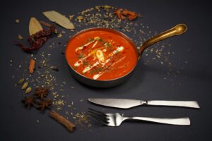 Chicken tikka masala curry with cream swirl served in a pan
