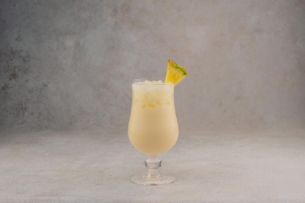 Creamy coconut rum cocktail with pineapple garnish