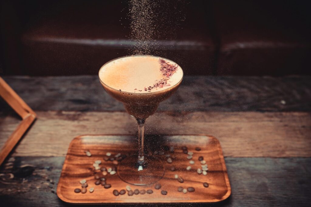 Coffee martini cocktail with crema and coffee beans in a martini glass