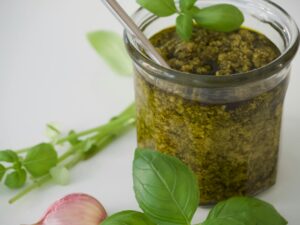 Fresh basil pesto in a jar with garlic and basil