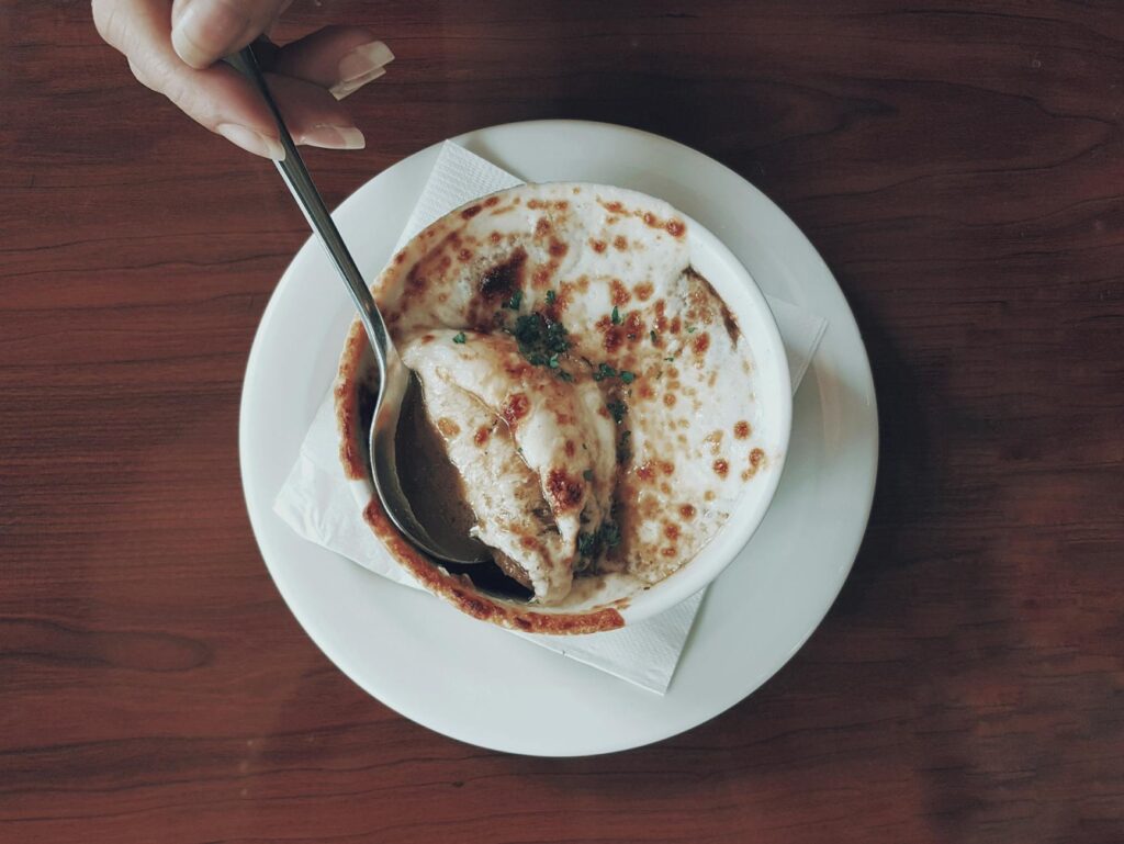 Classic French onion soup with bubbly Gruyère crouton in a ceramic crock