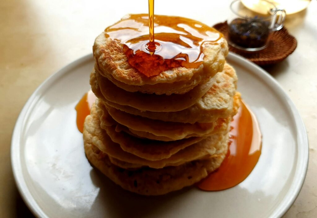 Fluffy buttermilk pancakes stacked with butter and maple syrup
