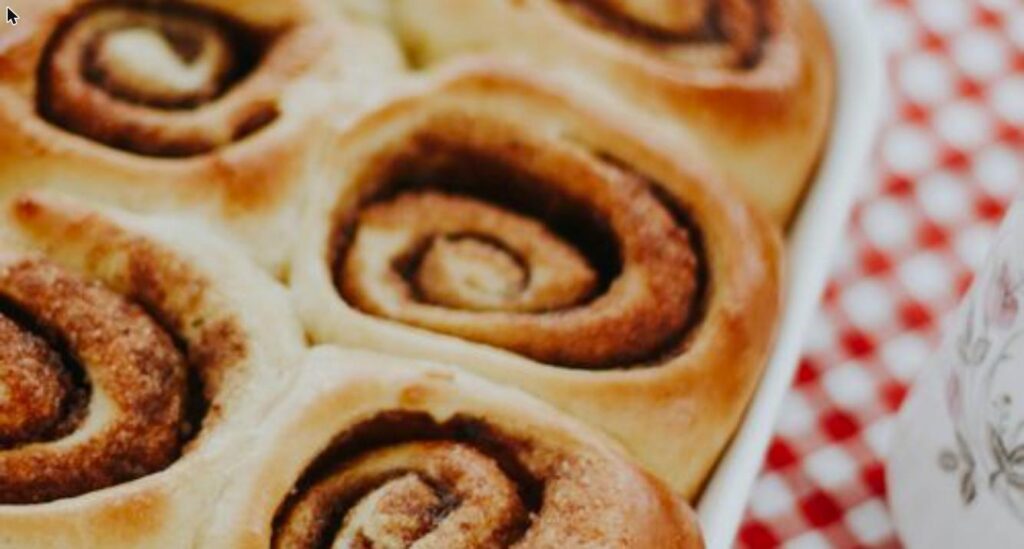 Freshly baked golden homemade cinnamon rolls in a baking pan